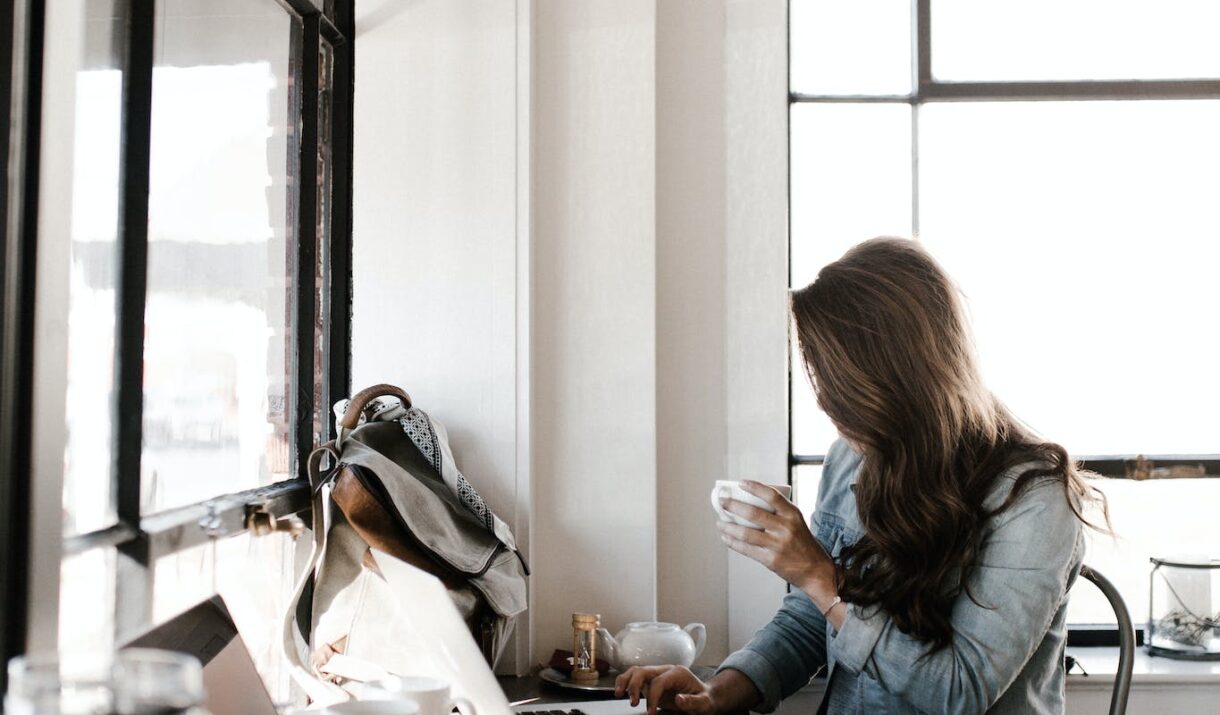 Woman in Gray Jacket Sitting Beside Desk